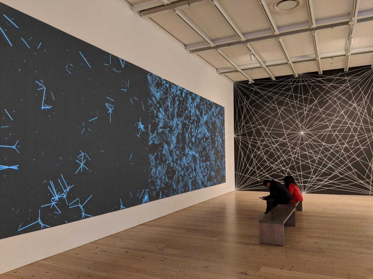 black wall with white lines drawn on it, next to a black wall with blue lines drawn on it.