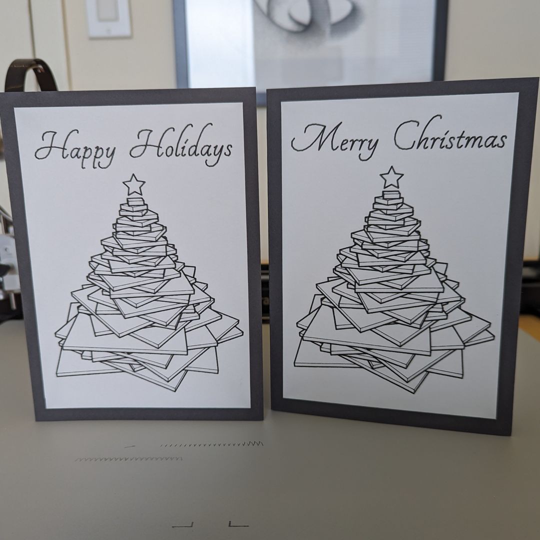 two holiday cards with a christmas tree on each and the words 