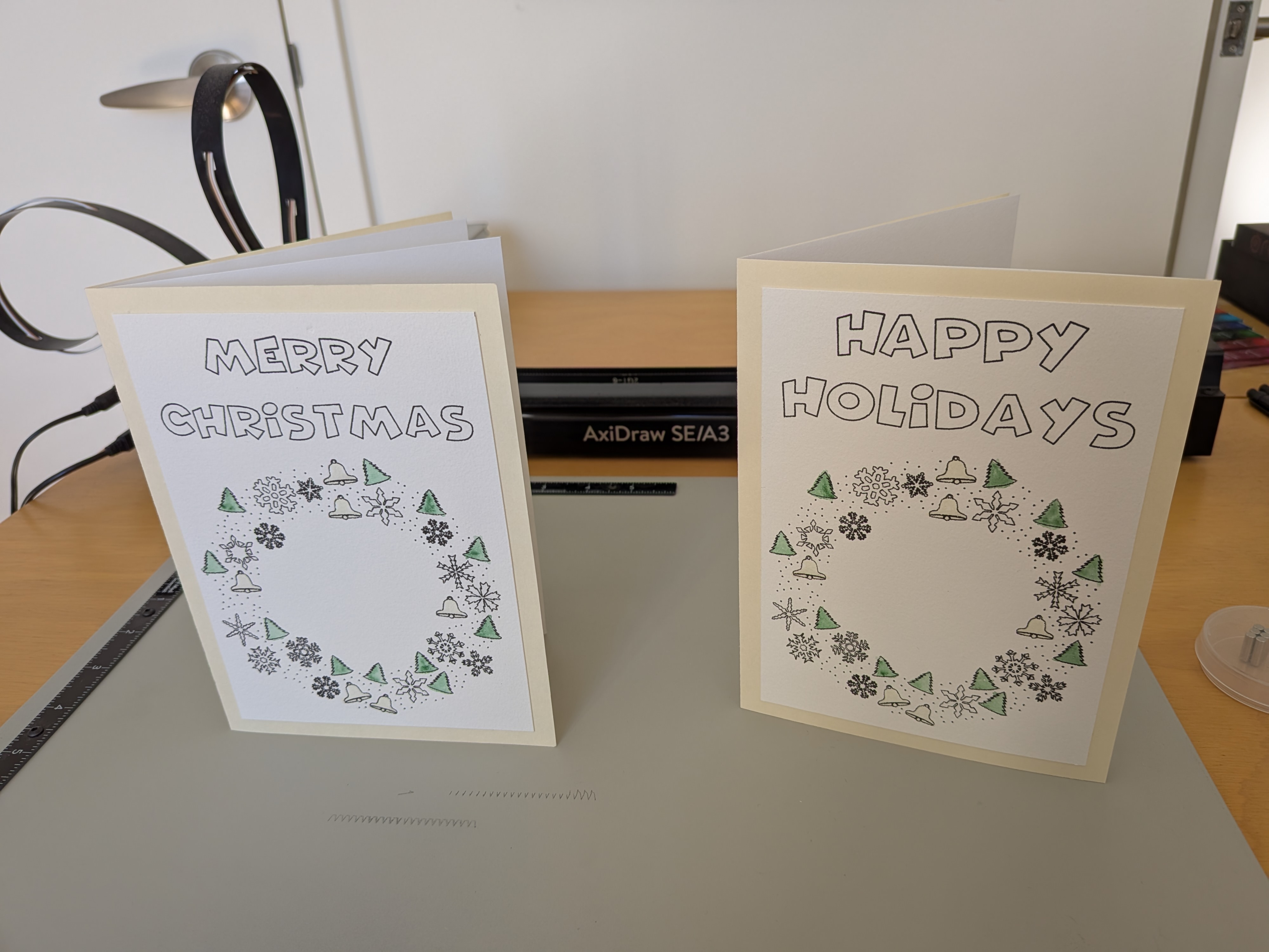 two holiday cards with a christmas wreath on each and the words 